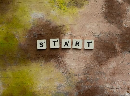 Scrabble letters spelling "START" on a textured earthy background.